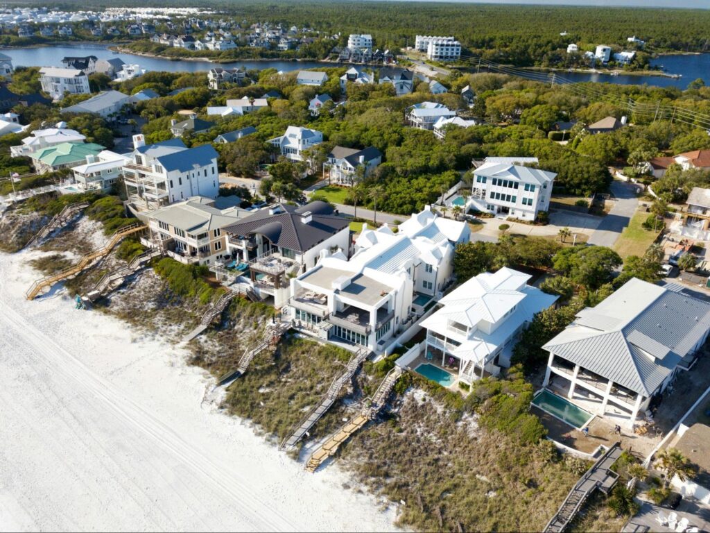 Aerial view of luxury beachfront estates and waterfront homes with private pools and beach access in Belleair Shore, Florida.